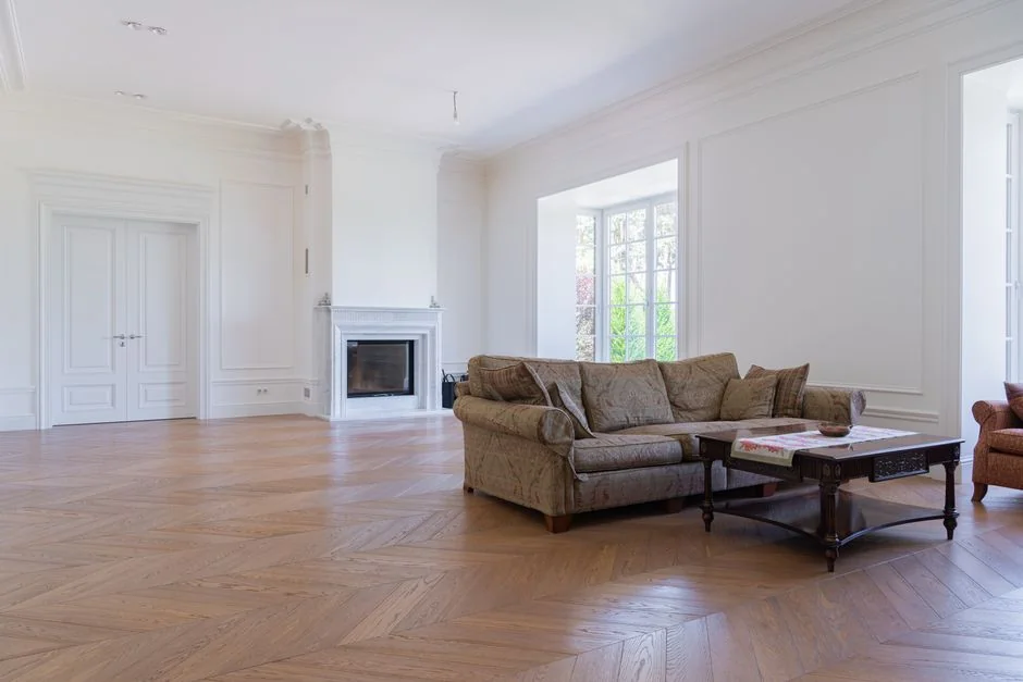 Couple preparing living room by covering the couch with protective white cloth.