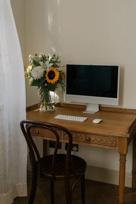 A mover carefully carries boxes through a bright, unfurnished room on moving day.